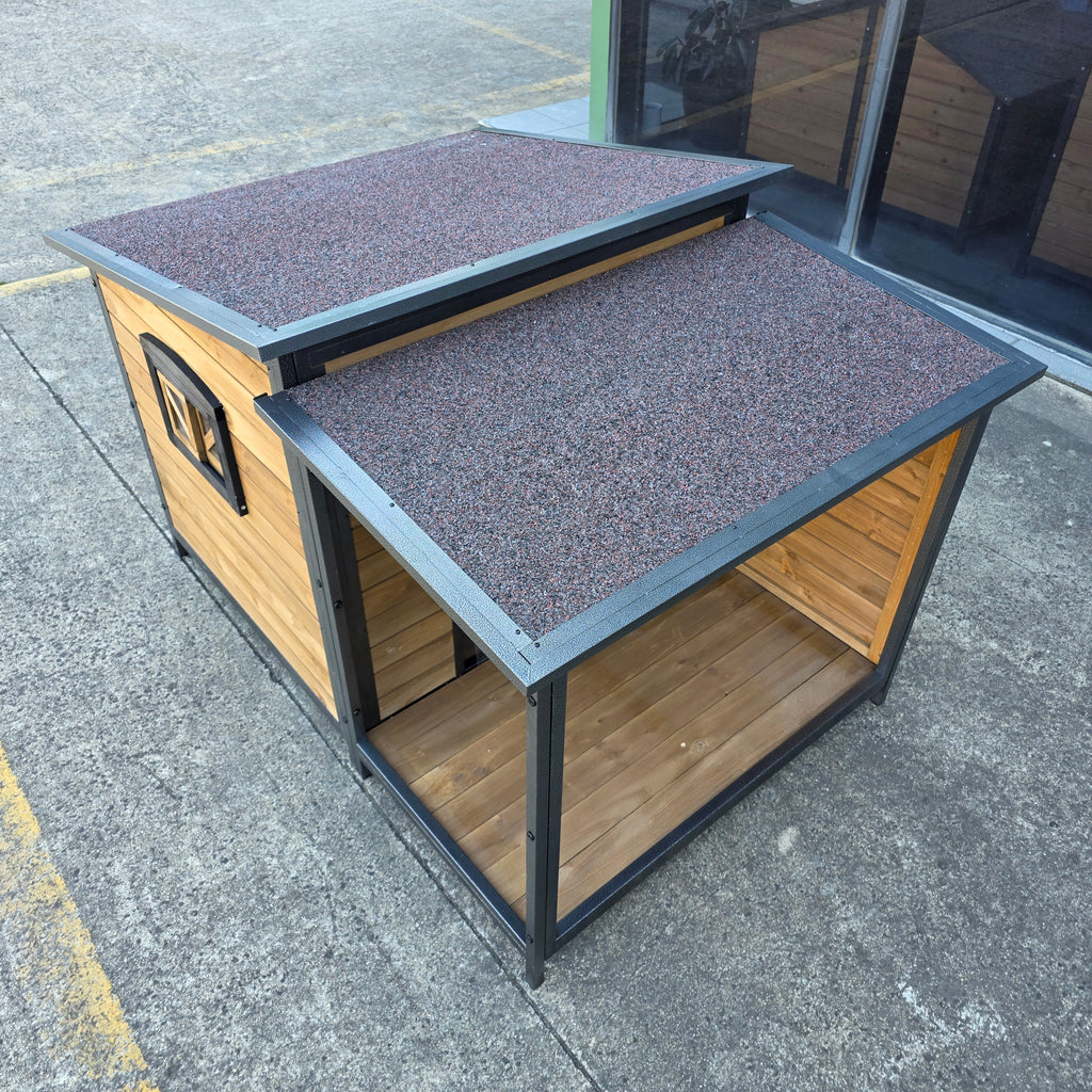 Wooden pet house with a gray roof on a concrete surface
